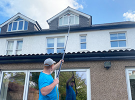 Lewis Cleaning Services cleaning windows using a water fed pole
