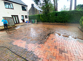 Commercial pressure washing service cleaning large car park or patio and driveway